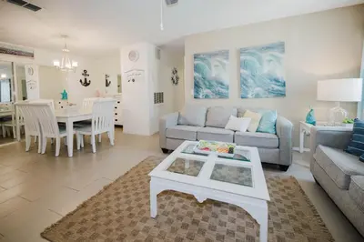 a living room with a couch and a table at Beach House That Sleeps 14 With Pool, Gym, Beach Access in Panama City Beach