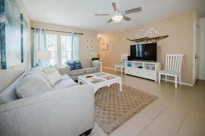 a living room with a couch and a tv at Beach House That Sleeps 14 With Pool, Gym, Beach Access in Panama City Beach