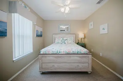 a bedroom with a bed and a ceiling fan at Beach House That Sleeps 14 With Pool, Gym, Beach Access in Panama City Beach