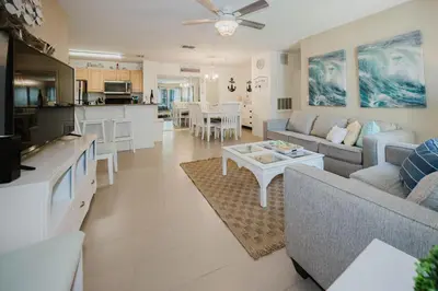 a living room with a couch and a table at Beach House That Sleeps 14 With Pool, Gym, Beach Access in Panama City Beach