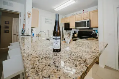 a bottle of wine sitting on a counter in a kitchen at Beach House That Sleeps 14 With Pool, Gym, Beach Access in Panama City Beach