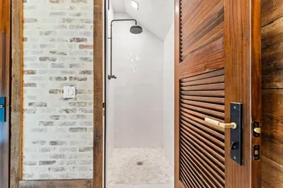 a door leading into a bathroom with a stone wall at Tranquility on the Preserve in Watersound Beach
