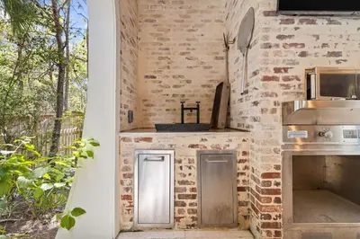 a kitchen with a brick wall and a counter at Tranquility on the Preserve in Watersound Beach