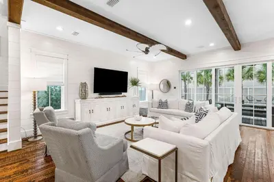 a living room with white furniture and a flat screen tv at Breezy Blue in Santa Rosa Beach