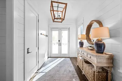 a hallway with a door and a table with a lamp at Breezy Blue in Santa Rosa Beach