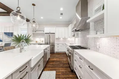 a white kitchen with white countertops and white cabinets at Breezy Blue in Santa Rosa Beach
