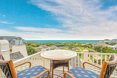 a balcony with a table and chairs and the ocean at Sunset at 409 in Watersound Beach