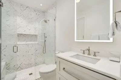 a white bathroom with a sink and a shower at Sunset at 409 in Watersound Beach