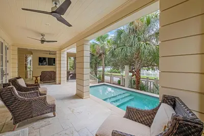 a swimming pool with chairs and a ceiling fan at Sunset at 409 in Watersound Beach