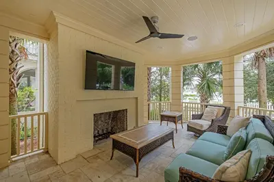 a screened porch with a couch and a fireplace at Sunset at 409 in Watersound Beach
