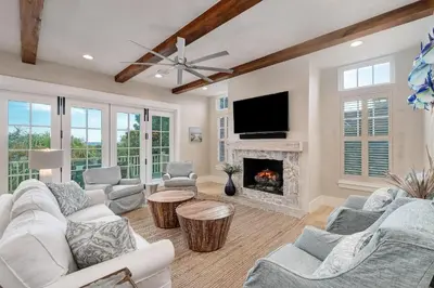 a living room with white furniture and a fireplace at Sunset at 409 in Watersound Beach