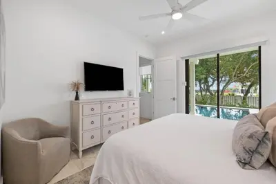 a bedroom with a bed and a tv and a chair at Eyes on Sunrise in Seacrest