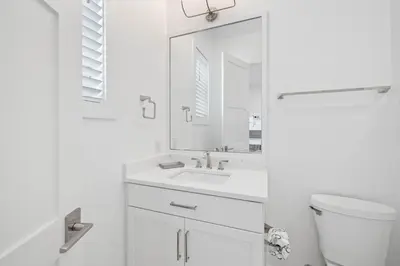 a white bathroom with a sink and a mirror at Eyes on Sunrise in Seacrest