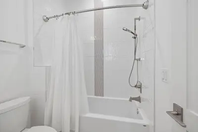 a white bathroom with a shower and a toilet at Eyes on Sunrise in Seacrest