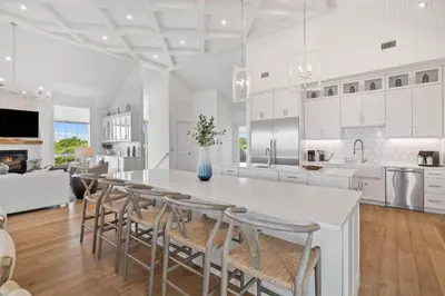 a white kitchen with a table and chairs at Eyes on Sunrise in Seacrest