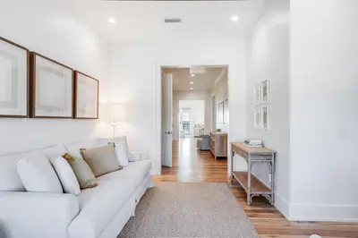 a white living room with a white couch and a table at Coastal Comfort in Seacrest