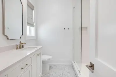 a white bathroom with a toilet and a shower at Coastal Comfort in Seacrest