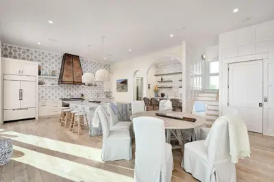a kitchen with white furniture and a table and chairs at Belle La Mer in Inlet Beach