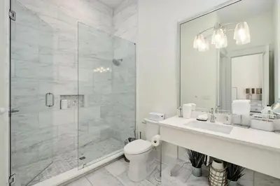 a bathroom with a shower and a toilet and a sink at Belle La Mer in Inlet Beach