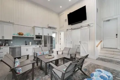 a living room with a table and chairs and a kitchen at Belle La Mer in Inlet Beach