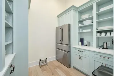 a kitchen with white cabinets and a stainless steel refrigerator at Belle La Mer in Inlet Beach