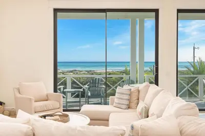 a living room with white furniture and a view of the ocean at Belle La Mer in Inlet Beach