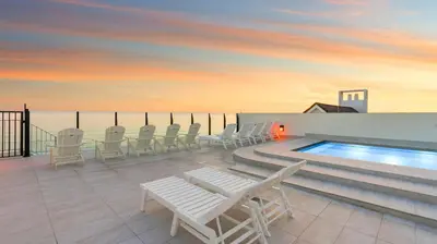 a patio with chairs and a swimming pool on a building at Azzurro Moon in Seagrove Beach
