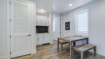 a kitchen with white cabinets and a wooden table at Azzurro Moon in Seagrove Beach