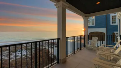 a porch with a view of the ocean at sunset at Azzurro Moon in Seagrove Beach