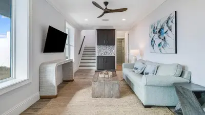 a living room with a blue couch and a tv at Azzurro Moon in Seagrove Beach