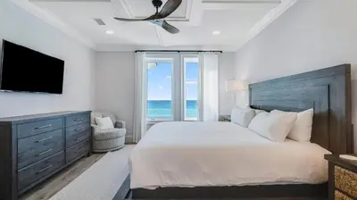 a bedroom with a bed and a television and the ocean at Azzurro Moon in Seagrove Beach