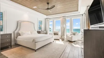 a bedroom with a bed and a tv and some windows at Azzurro Dream in Seagrove Beach