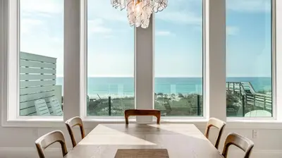 a dining room with a table and views of the ocean at Azzurro Dream in Seagrove Beach