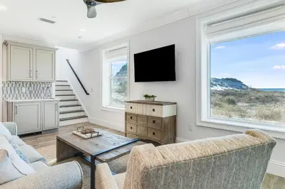 a living room with a couch and a tv at Azzurro Sky in Seagrove Beach