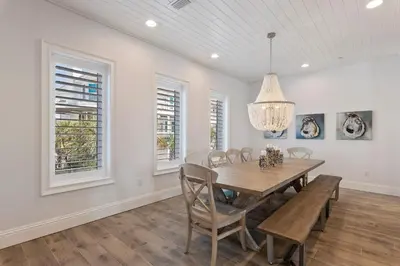 a dining room with a wooden table and chairs at Azzurro Sky in Seagrove Beach