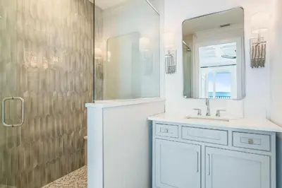 a white bathroom with a sink and a shower at Azzurro Sky in Seagrove Beach