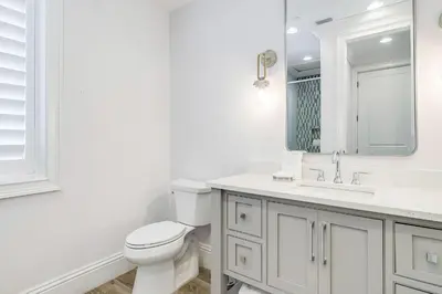 a white bathroom with a toilet and a sink at Azzurro Sky in Seagrove Beach