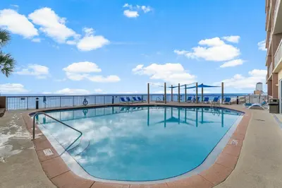 a large swimming pool with the ocean in the background at 1002 Sunrise Beach in Panama City Beach
