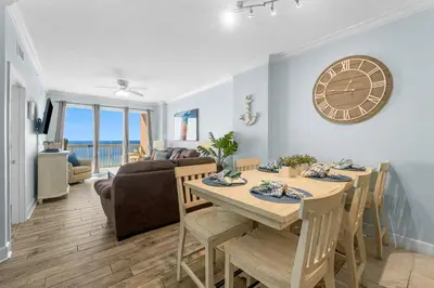 a dining room with a table and a clock on the wall at 1002 Sunrise Beach in Panama City Beach