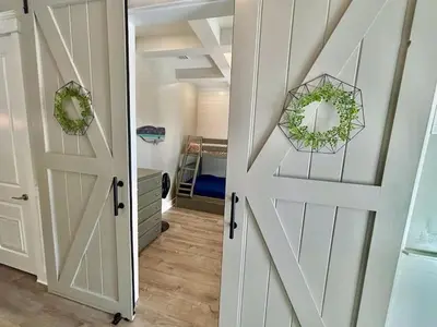 a room with a sliding door and a bedroom at Majestic View Beach House in Panama City Beach
