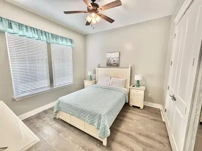 a bedroom with a bed and a ceiling fan at Majestic View Beach House in Panama City Beach