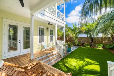 a front porch of a house with a green lawn at 30A Beach House - Under the Palms by Panhandle Getaways in Santa Rosa Beach