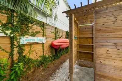 a house with a surfboard on the side of it at 30A Beach House - Under the Palms by Panhandle Getaways in Santa Rosa Beach