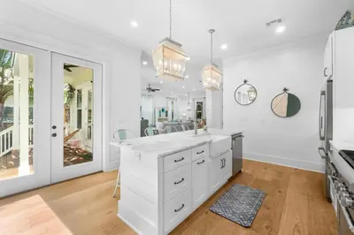a white kitchen with a sink and a mirror at 30A Beach House - Under the Palms by Panhandle Getaways in Santa Rosa Beach