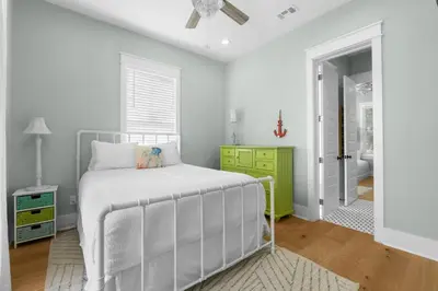 a white bedroom with a bed and a bathroom at 30A Beach House - Under the Palms by Panhandle Getaways in Santa Rosa Beach