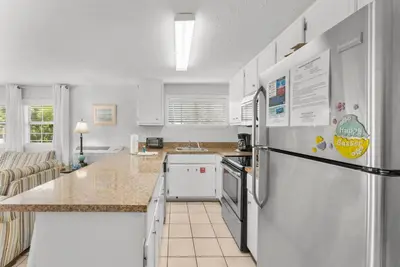 a kitchen with a refrigerator and a counter top at Island Time Bungalow in Panama City Beach