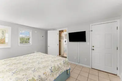 a bedroom with a bed and a flat screen tv at Island Time Bungalow in Panama City Beach