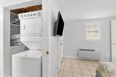 a kitchen with a stove and a washer and dryer at Island Time Bungalow in Panama City Beach