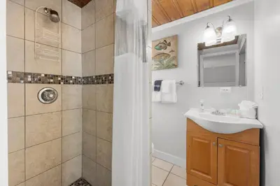 a bathroom with a shower and a sink at Island Time Bungalow in Panama City Beach