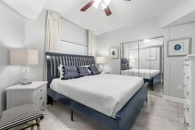 a bedroom with a blue and white bed and a mirror at Shores Of Panama #1930 in Panama City Beach
